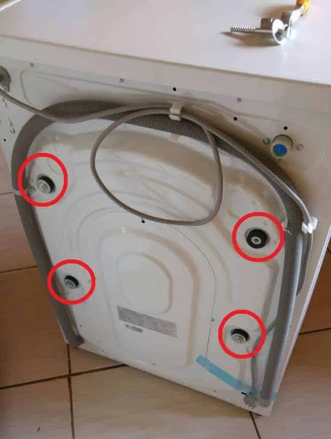 Rückansicht einer Waschmaschine, die Positionen der Transportsicherungen sind rot markiert