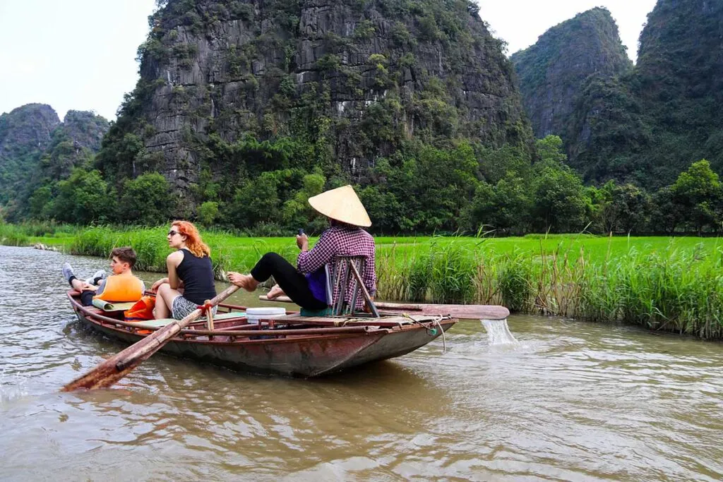 Ruderboot auf dem Fluss durch die Karstfelsen von Tam Coc, ein friedliches Erlebnis in Ninh Binh