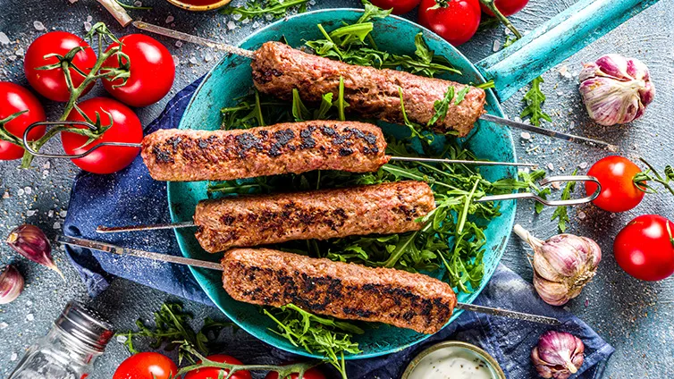 Saftige Cevapcici, perfekt gegrillt und appetitlich auf einem Teller angerichtet.