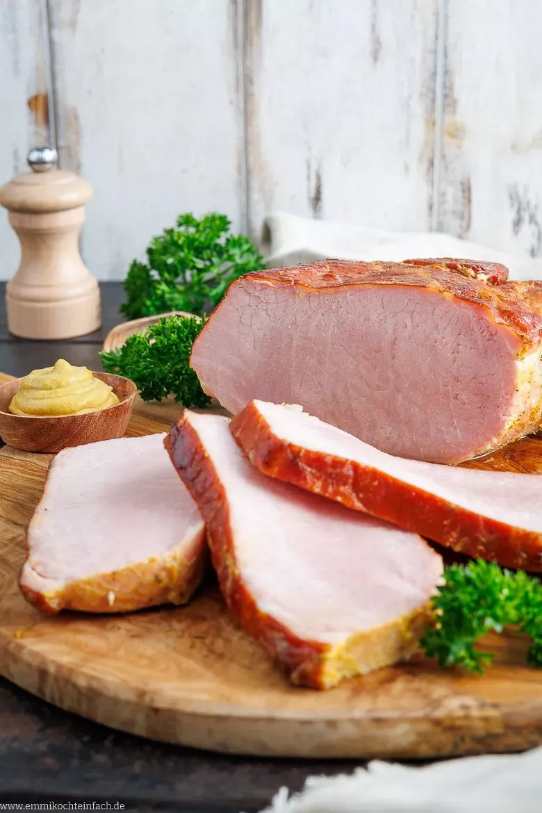 Saftige Scheiben Kasslerbraten angerichtet mit traditionellem Sauerkraut und cremigem Kartoffelpüree.