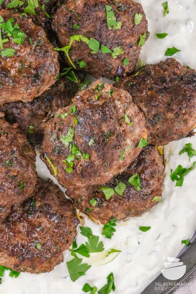 Saftige türkische Köfte, appetitlich angerichtet und mit frischer Petersilie bestreut, bereit zum Genuss.