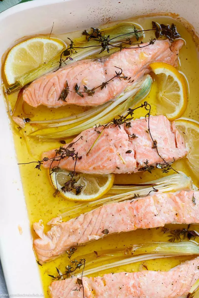 Saftiges Zitronen-Lachsfilet im Backofen, umgeben von frischen Zitronenscheiben und duftendem Thymian, perfekt für ein schnelles Lachsfilet Rezept.