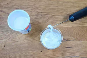 Sahne mit einem Milchaufschäumer steif schlagen