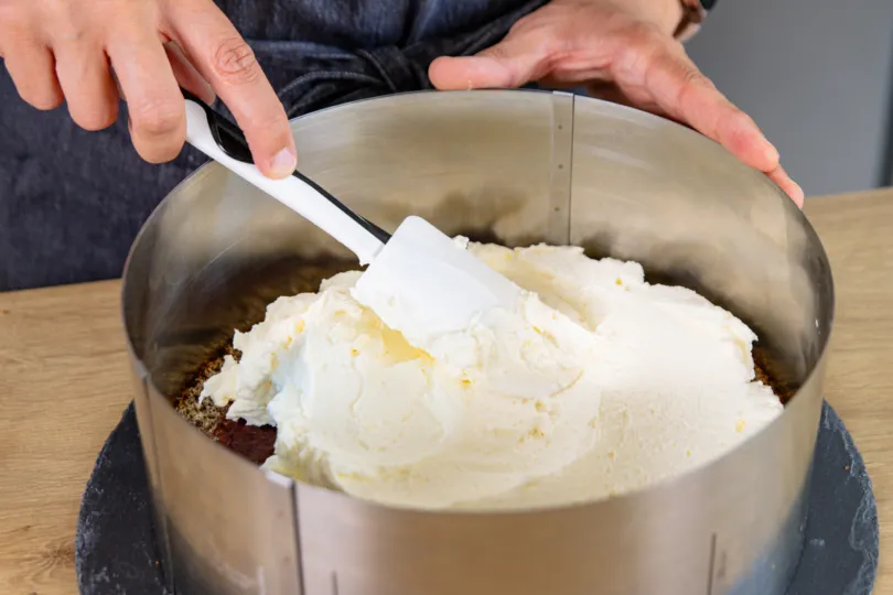 Sahnecreme auf den unteren Tortenboden verteilen