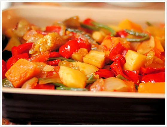 Sanft aus dem Topf gehobenes, geschmortes Ratatouille-Gemüse bereit zum Rösten im Ofen