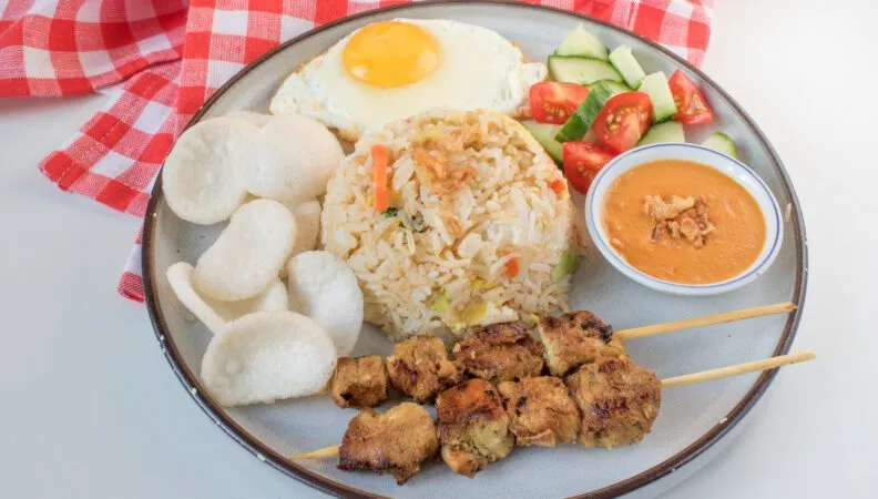 Saté-Spieße mit Erdnusssauce und Kroepoek-Chips, ein beliebtes Gericht mit indonesischem Einfluss