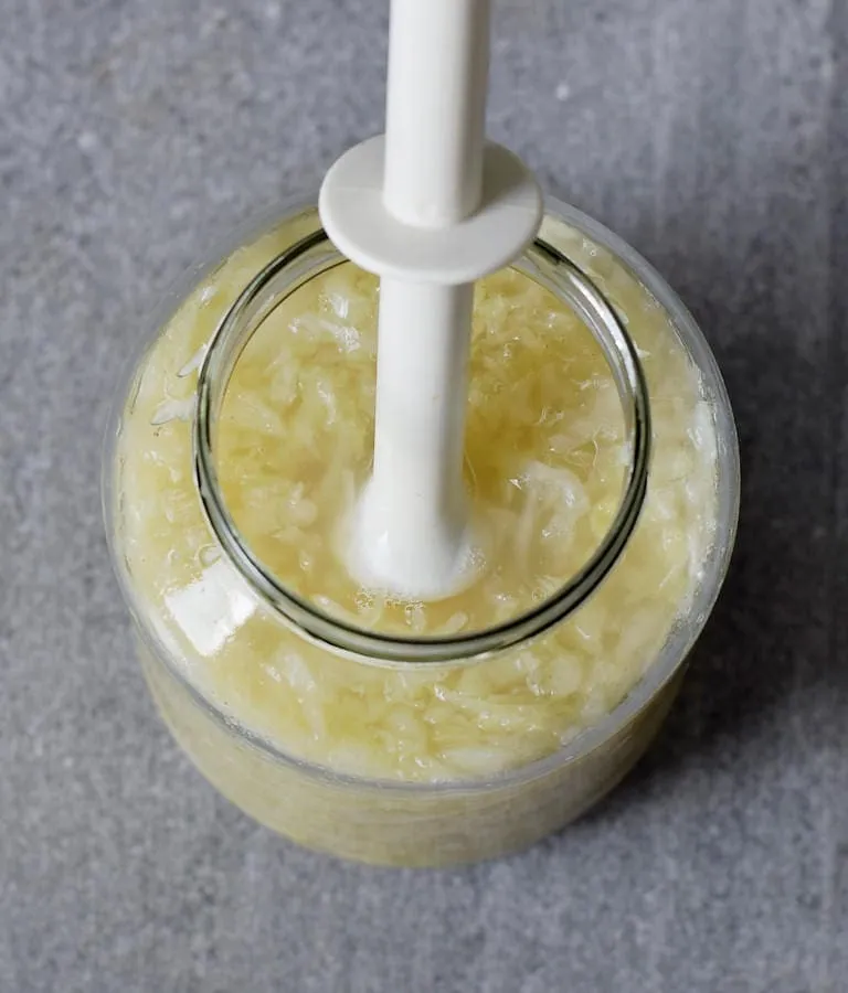 Sauerkraut mit einem Stößel zusammendrücken
