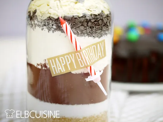 Schichtweise eingefüllte Zutaten für die Geburtstagskuchen Backmischung im Glas, inklusive Schokostreusel.