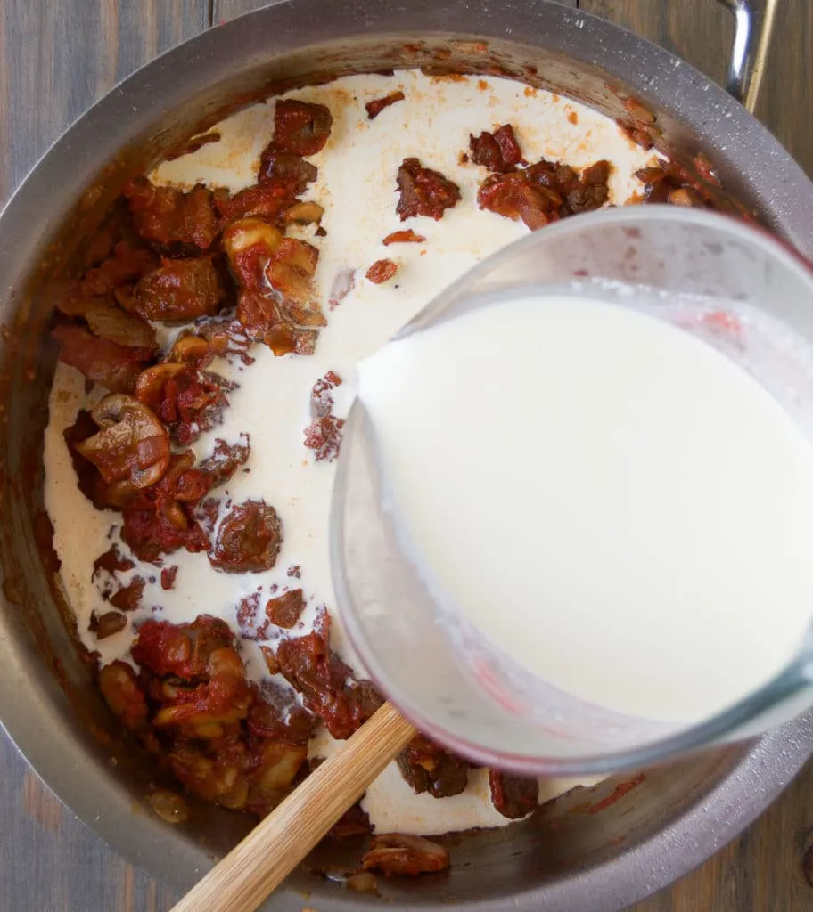 Schlagsahne in die Stroganoff-Soße einrühren für Cremigkeit