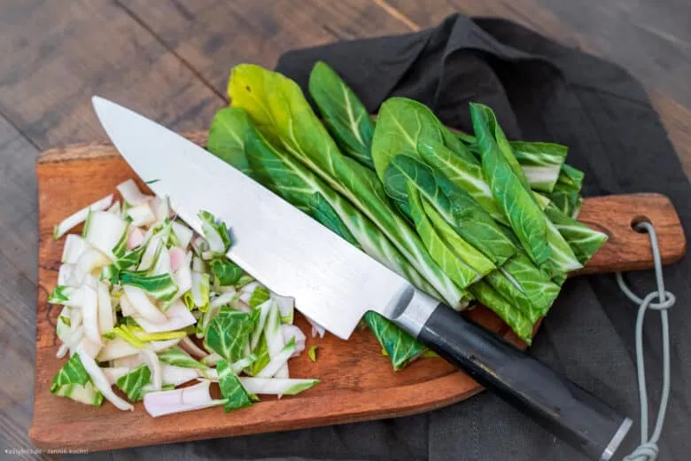 Schneiden von Mangoldstielen und -blättern für die getrennte Zubereitung, ein wichtiger Schritt im Rezept.