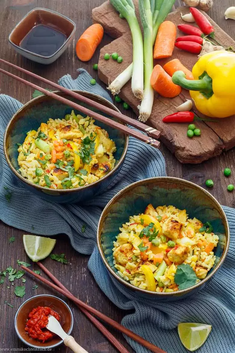 Schnelle und einfache asiatische Reispfanne mit goldbraunem Hähnchen und Gemüse im Wok zubereitet