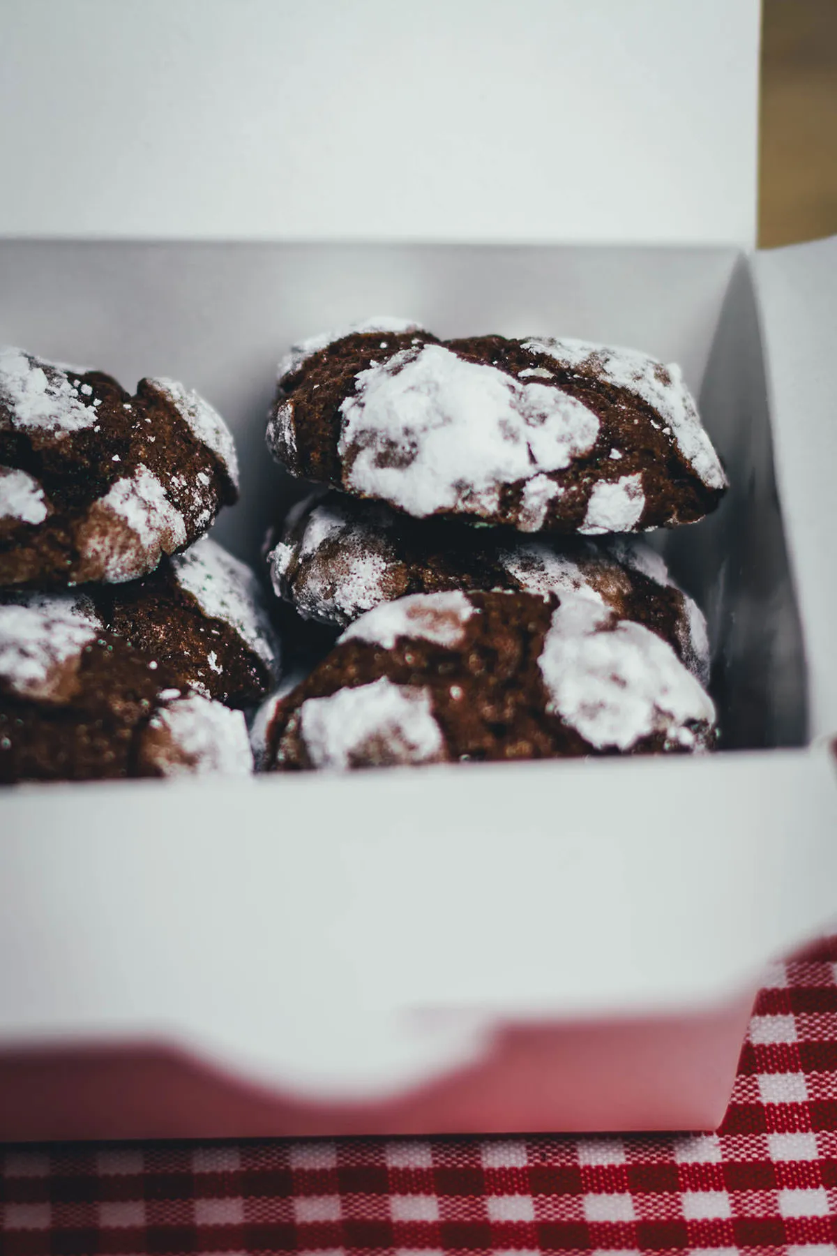 Schoko-Knusper-Kekse, auch bekannt als Chocolate Crinkle Cookies, mit Puderzucker bestäubt für eine winterliche Optik. Sie sind außen knusprig und innen weich, ideal für einfache Weihnachtskekse.