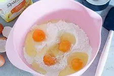 Schritt 1 der Spätzleteig Zubereitung: Mehl, Salz und Eier in einer Rührschüssel vermengen.