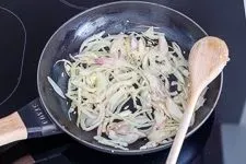 Schritt 1: Schalotten und Knoblauch in Olivenöl andünsten für das Zucchini-Aubergine-Rezept.