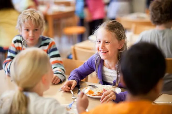 Schulkinder beim Mittagessen in Schweden, symbolisierend das kindzentrierte schwedische Schulsystem und das Prinzip, kein Kind zurückzulassen.