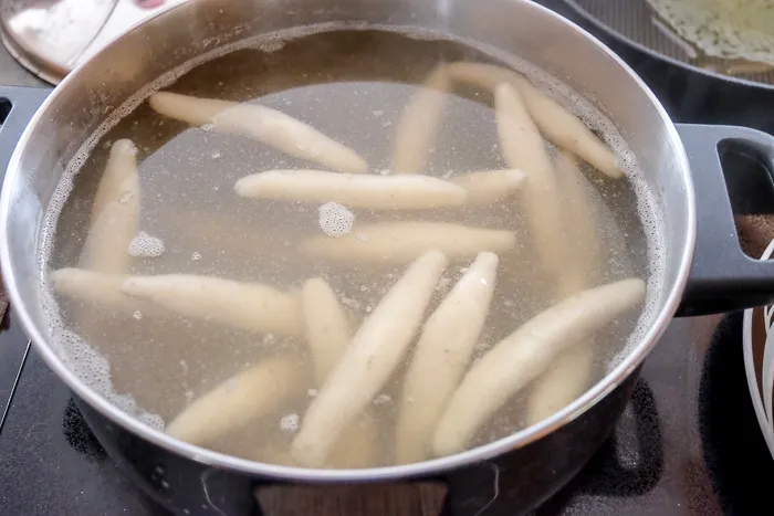 Schupfnudeln kochen leicht siedend in gesalzenem Wasser im Topf.