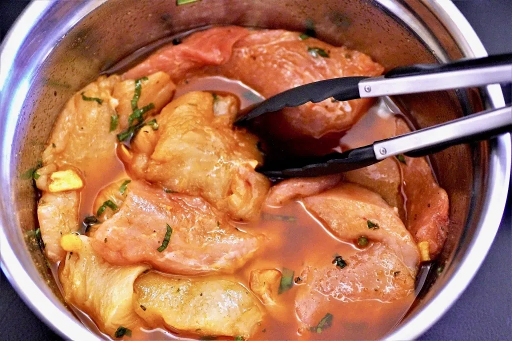 Schüssel mit rohem Fleisch, Kräutern und Apfelessig-Marinade für intensiven Geschmack