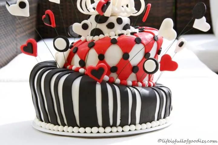 Seitliche Ansicht der geschichteten Topsy Turvy Torte mit roten und hellen Biskuitböden vor dem Fondantüberzug.