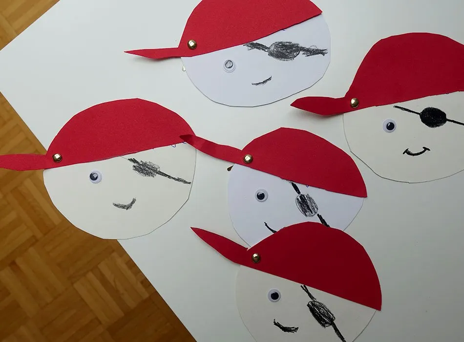 Selbstgebastelte Piraten-Einladungskarten mit aufgemalten Gesichtern für einen Kindergeburtstag.