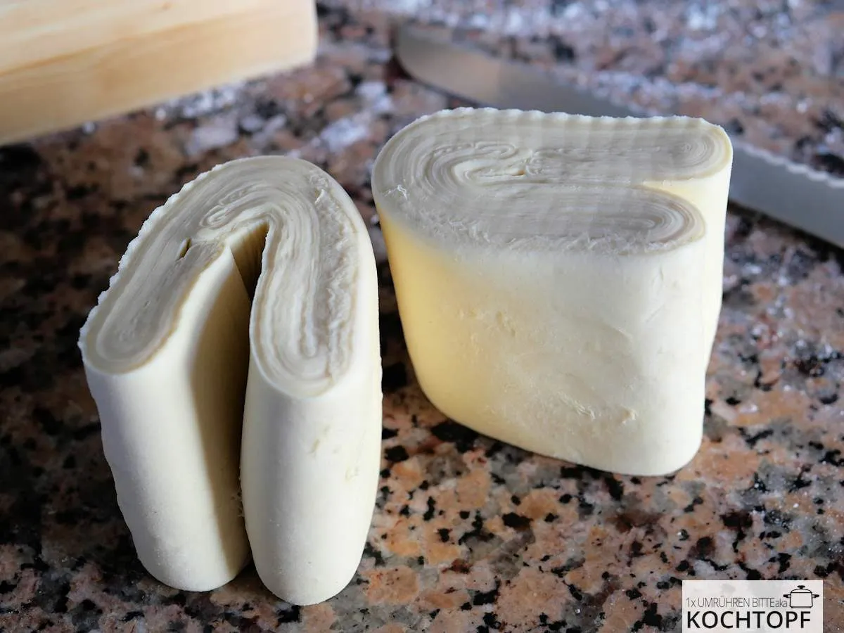 Selbstgemachter Blätterteig, frisch halbiert und perfekt geschichtet, bereit zur Weiterverarbeitung. Ideal für luftige Gebäcke.