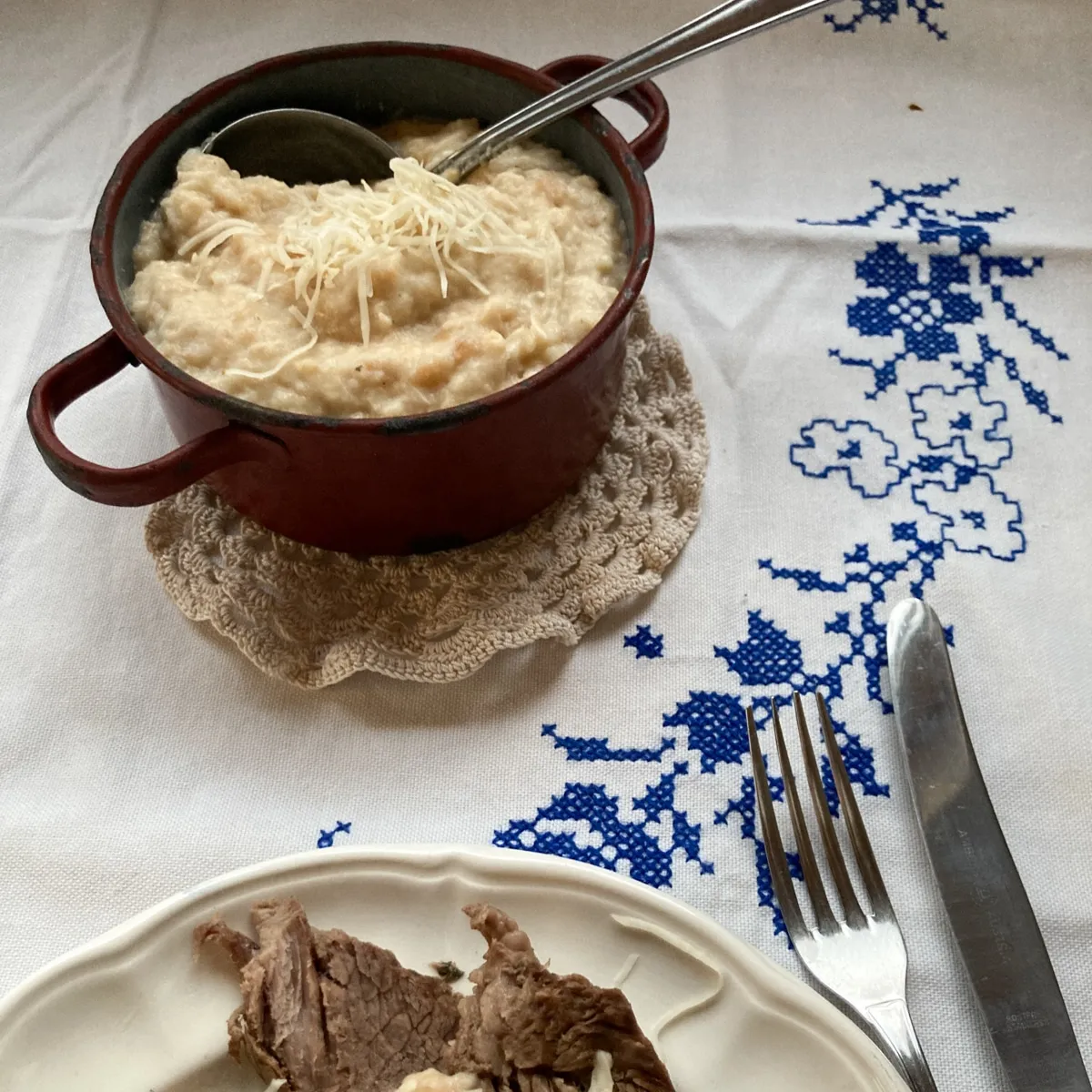 Semmelkren angerichtet in rustikalem Topf, Teller mit gekochtem Rindfleisch in Scheiben. Ein rustikales Gericht mit feinem Geschmack, perfekt für besondere Anlässe und Liebhaber der österreichischen Küche.