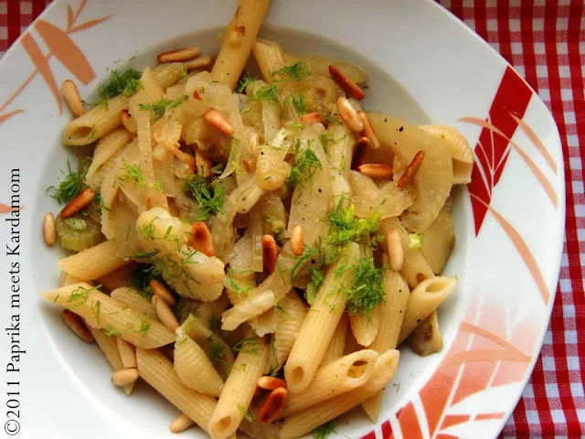 Servierfertige Fenchelpasta nach Rainer Sass mit frischem Grün, gerösteten Pinienkernen und geriebenem Käse