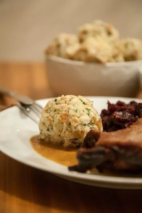 Servierfertige Gänsekeule auf dem Teller mit Rotkohl und Knödeln