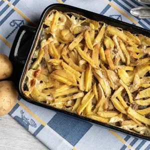 Servierfertige Janssons Versuchung: Ein festlicher schwedischer Kartoffelauflauf, traditionell zu Weihnachten genossen, goldbraun gebacken.