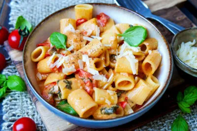 Servierfertige One Pot Pasta mit frischen Kirschtomaten, aromatischem Basilikum und geriebenem Parmesan, ein blitzschnelles Nudelgericht.