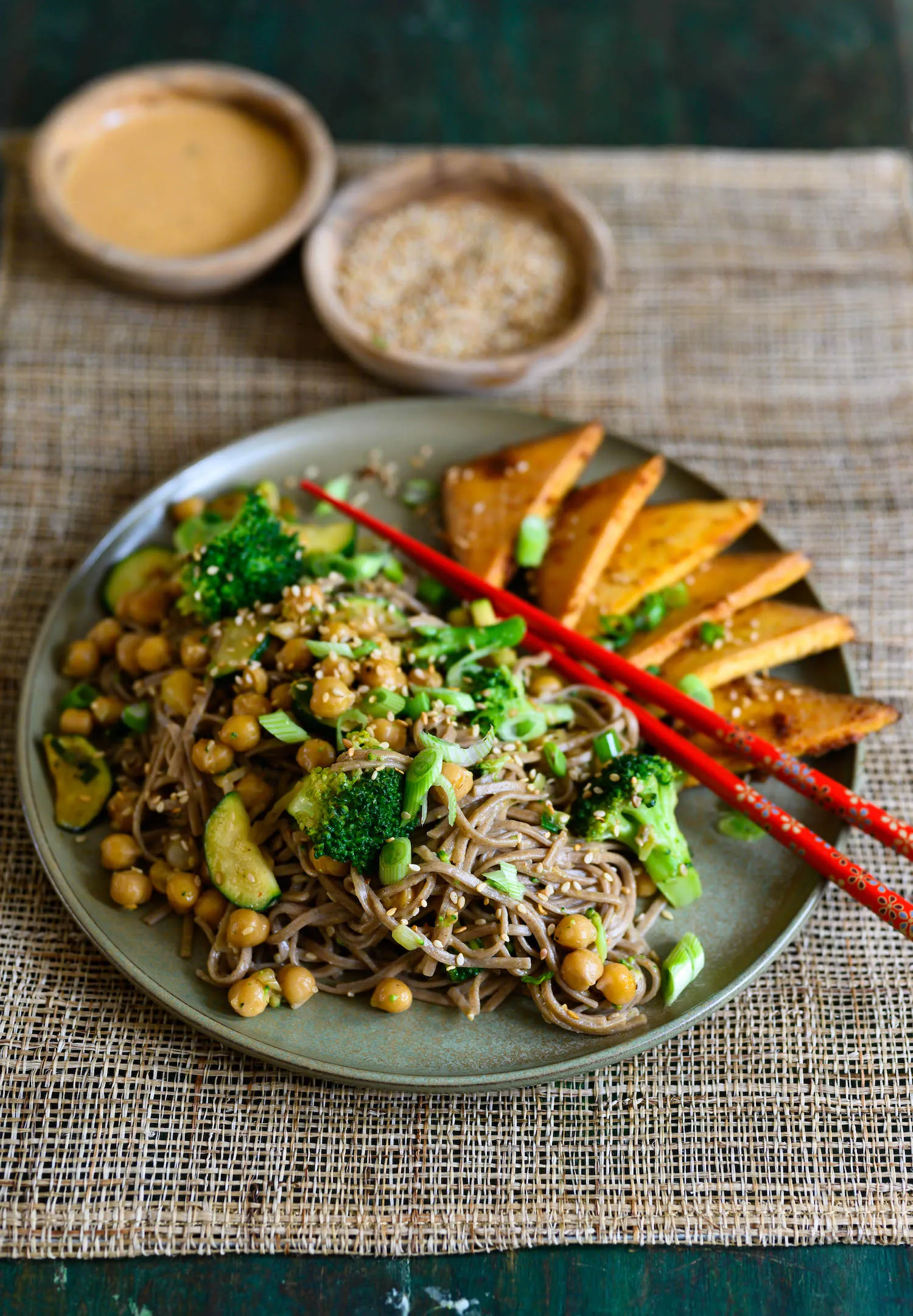 Servierfertige Portion Soba-Nudeln mit grünem Gemüse und Räuchertofu, appetitlich angerichtet mit frisch gehackten Kräutern und Dressing.