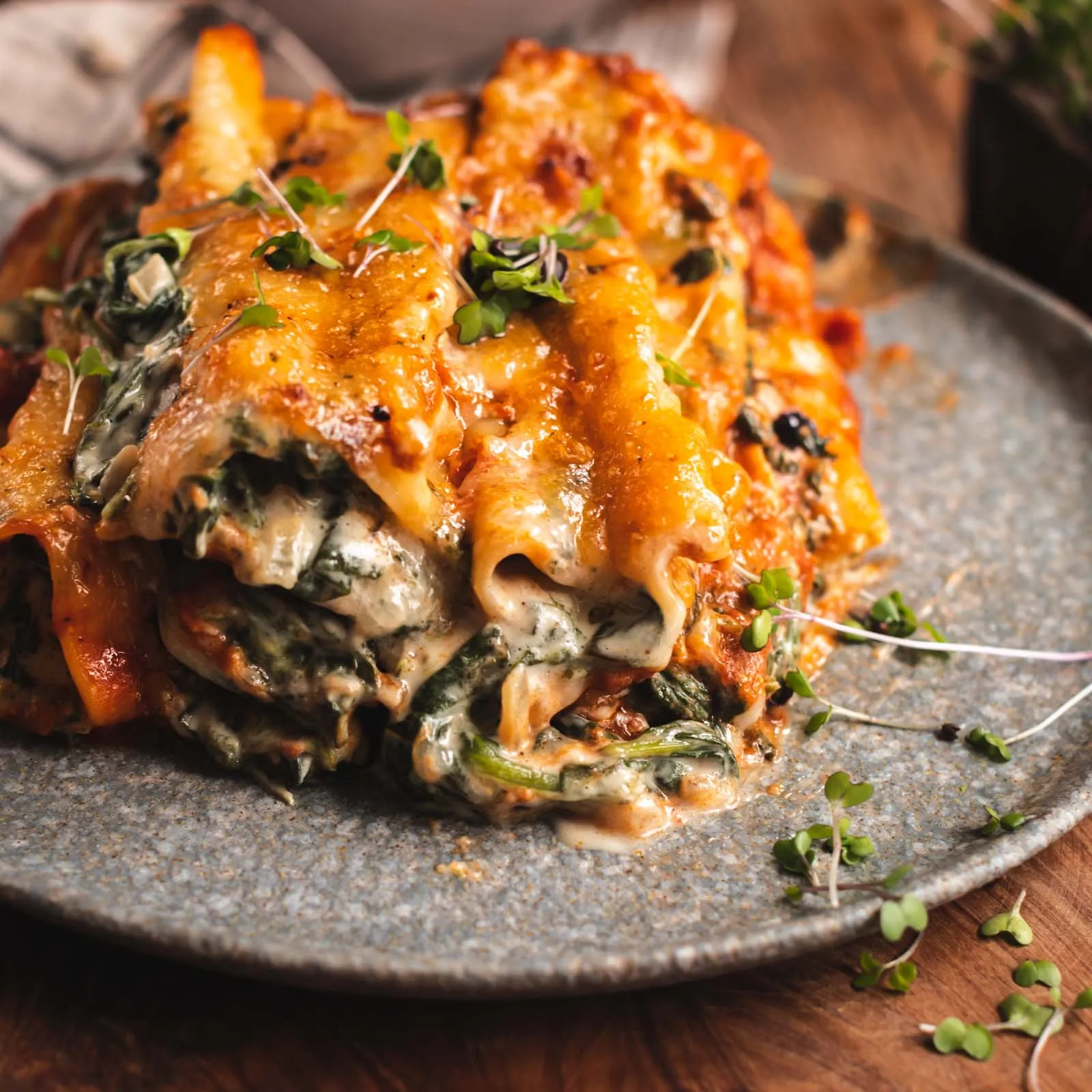 Servierfertige vegane Cannelloni mit Spinatfüllung auf dem Teller