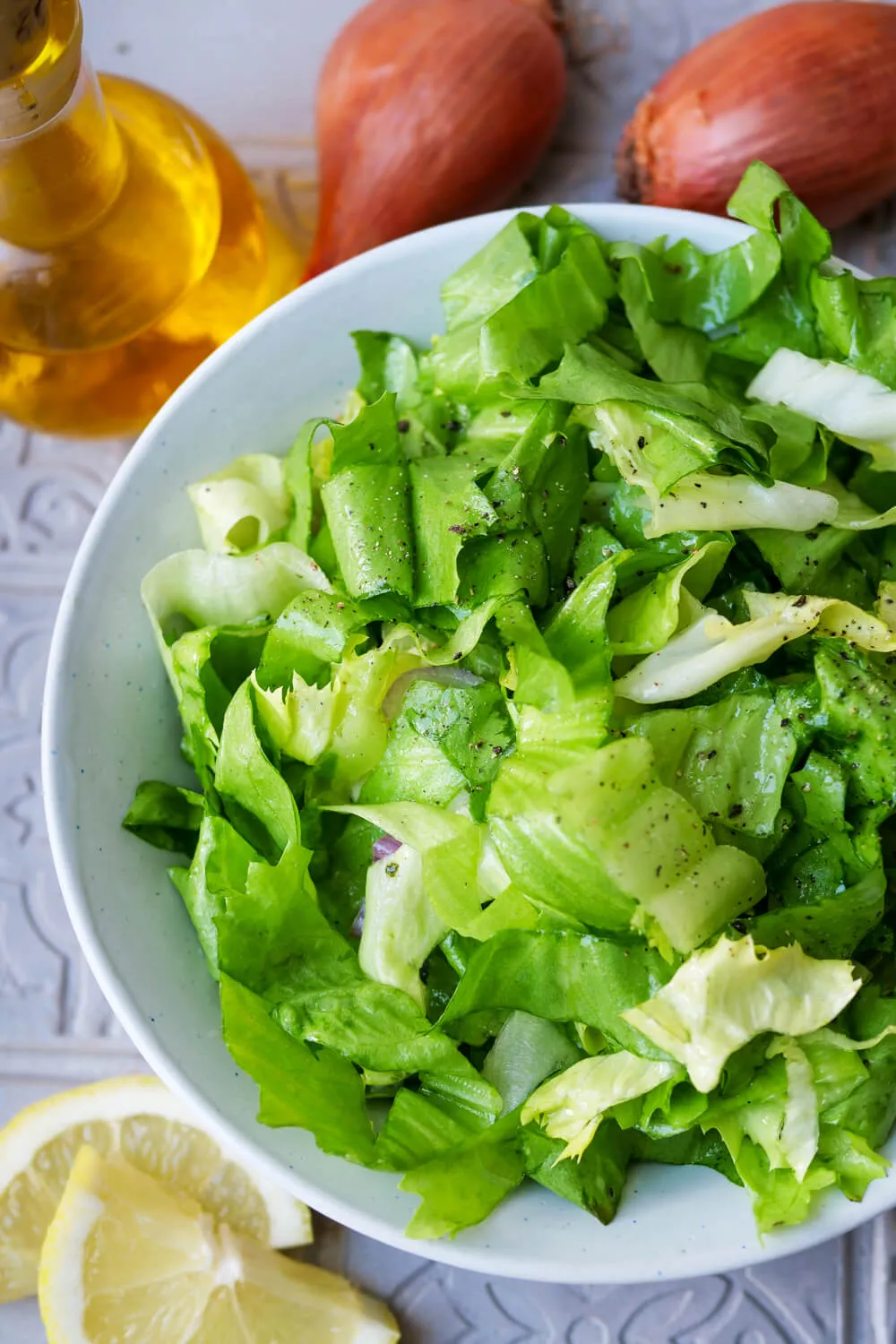 Servierfertiger Endiviensalat mit Honig-Senf-Dressing auf einem weißen Teller.