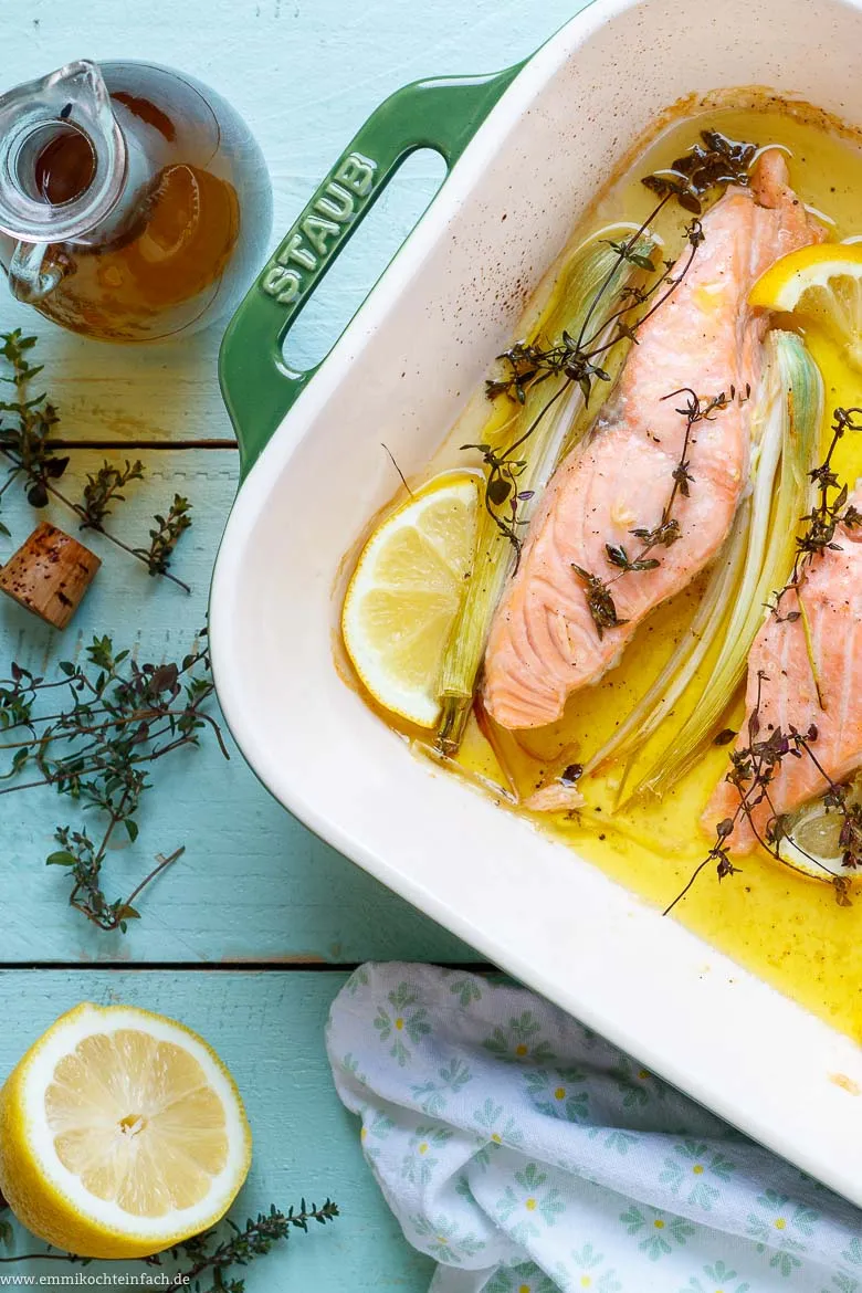 Servierfertiger Zitronen-Lachs aus dem Backofen, begleitet von frischem Baguette zum Tunken in die köstliche Soße.
