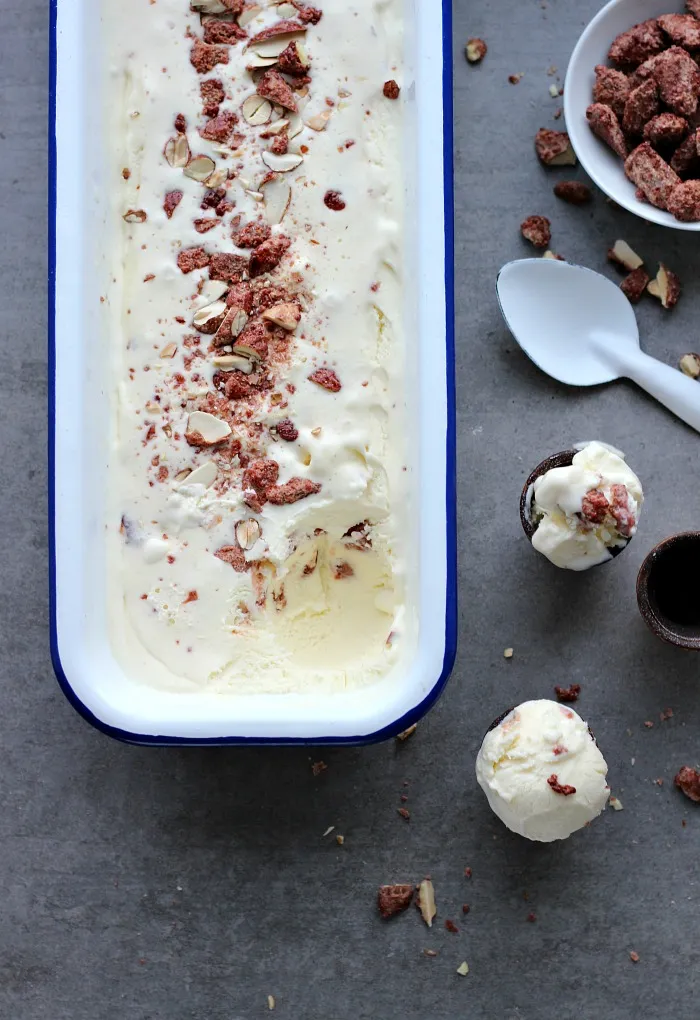 Servierfertiges Sahneeis im Glas, garniert mit ganzen gebrannten Mandeln – ideales festliches Weihnachtsdessert