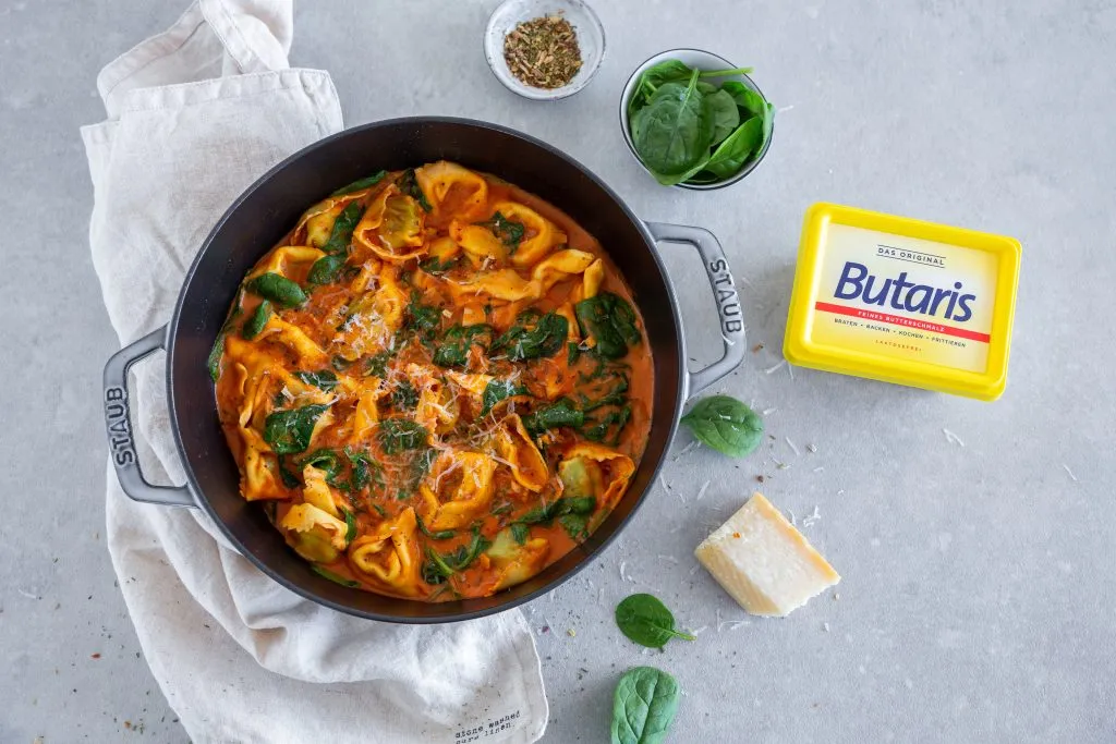 Servierte Tortellini Soße mit reichlich geriebenem Parmesan, bereit zum Genießen