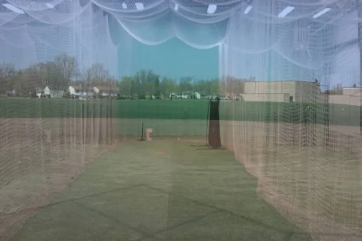 Sich den Käfig im Kopf auf einem Fastpitch-Softballfeld vorstellen