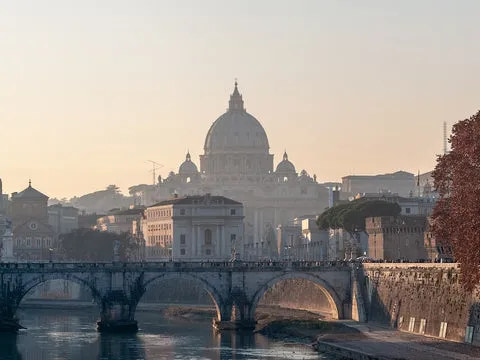 Sicht auf den Petersdom in Rom mit Blick auf eine Brücke bei Sonnenuntergang