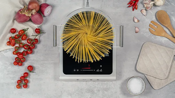 Smeg Kochfeld mit Pasta Topf neben Tomaten und Kochbesteck