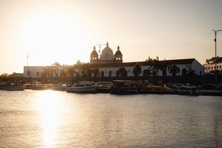 Sonnenuntergang über einer deutschen Stadt mit Kathedrale, im Vordergrund Boote auf dem Meer