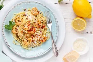 Spaghetti mit Garnelen, frisch serviert und verfeinert mit geriebenem Parmesan und Zitronenspalten für extra Aroma