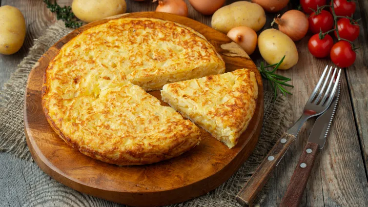 Spanische Tortilla mit vielen Kartoffeln auf einem Holzbrett