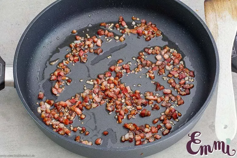 Speck wird in der Pfanne für die Carbonara angebraten