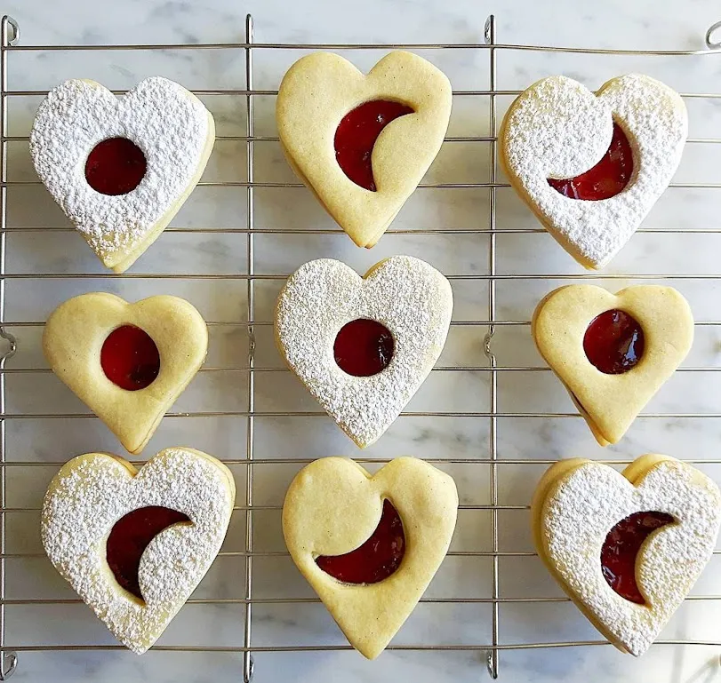 Spitzbuben mit roter Konfitüre gefüllt und Puderzucker bestäubt