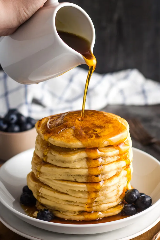 Stapel fluffiger Pancakes, übergossen mit Ahornsirup