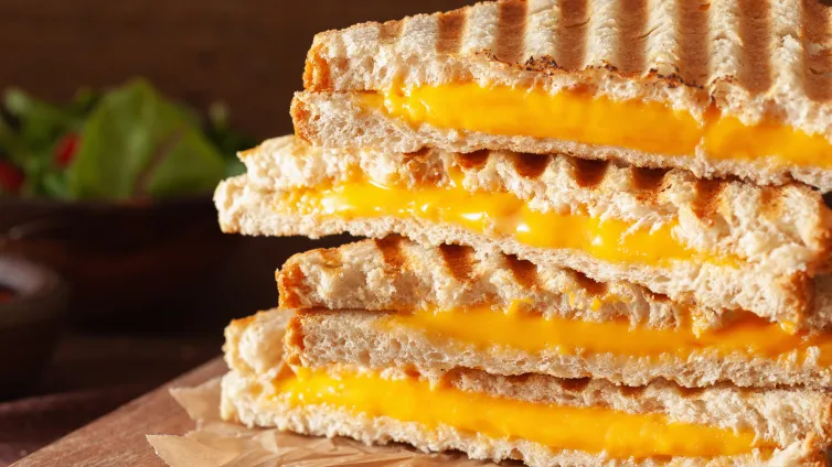 Stapel goldbrauner Grilled Cheese Sandwiches mit geschmolzenem Käse, angerichtet zum Servieren.