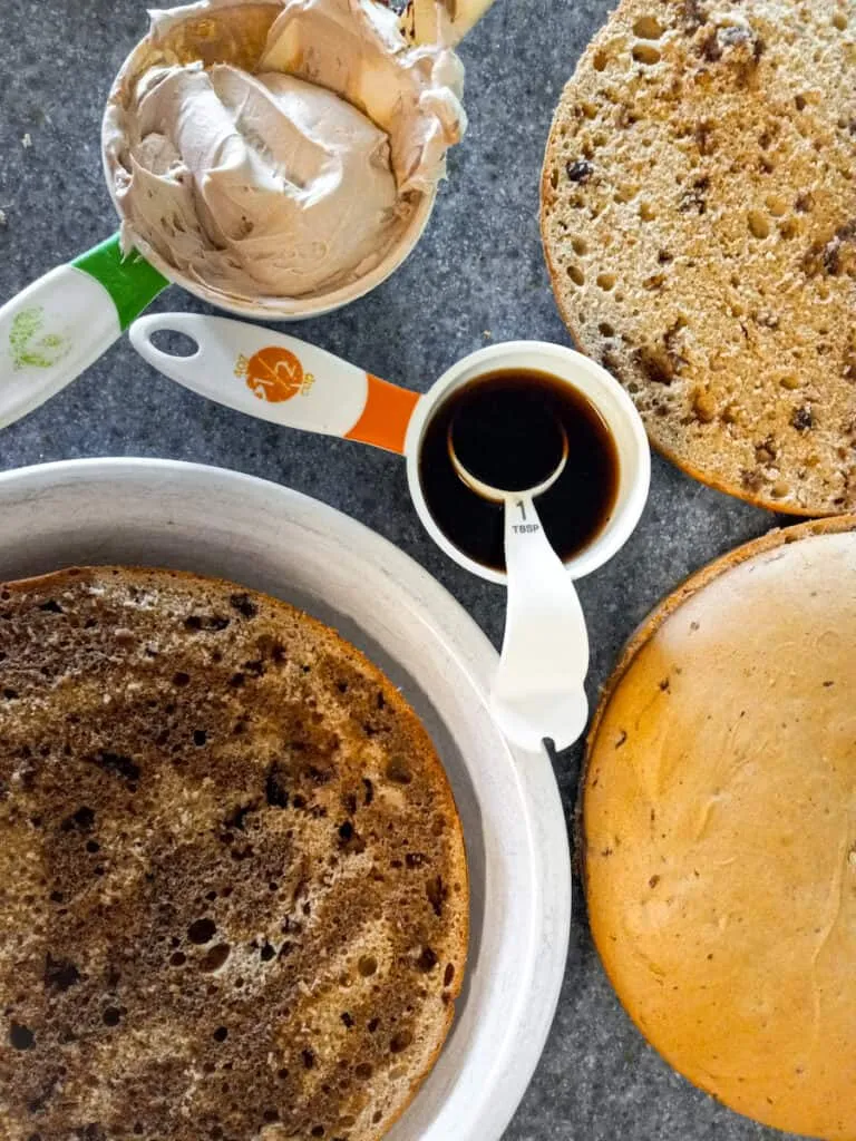 Starker Kaffee wird über dünn geschnittene Schichten des Tortenbodens geträufelt, um die Tiramisu Torte saftig zu machen.