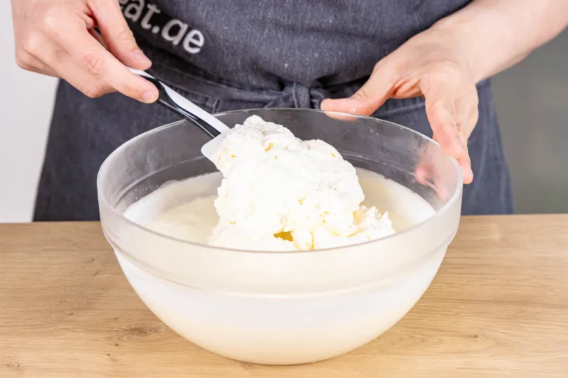 Steif geschlagene Sahne vorsichtig unter die Joghurtcreme heben