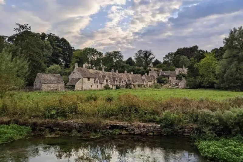 Steinhäuser neben einer Wiese an einem Fluss in Bibury in den Cotswolds