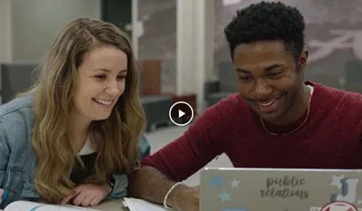 Studenten unterhalten sich an einem Laptop in einem modernen Café in Deutschland