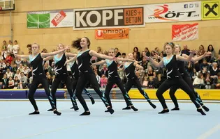 Team Turnen Athleten feiern gemeinsam nach einer erfolgreichen Übung